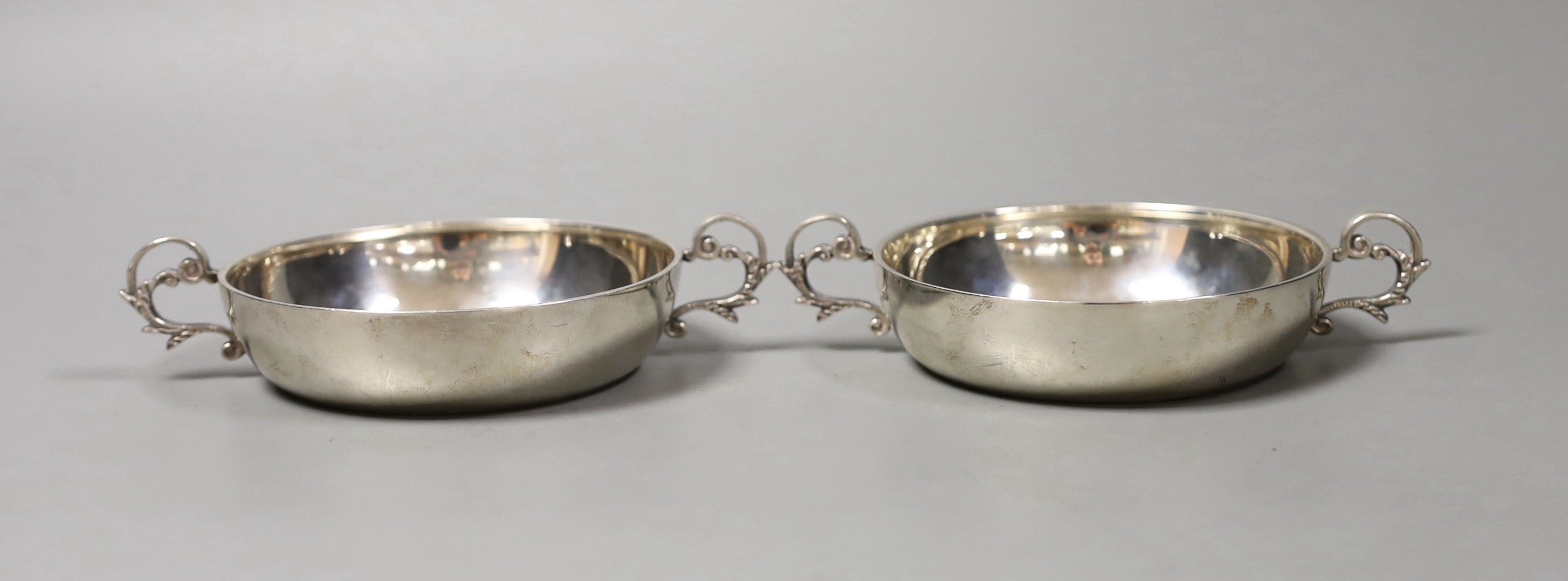 A pair of modern silver two-handled shallow nut dishes, with engraved inscription to the base, Royal Irish Silver Co. Sheffield, 1973, 15.1cm over handles, 193 grams.